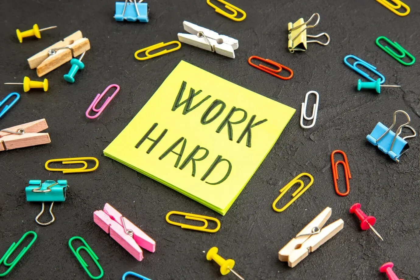 Frontalansicht eines Motivationszettels mit Wäscheklammern und Heftklammern